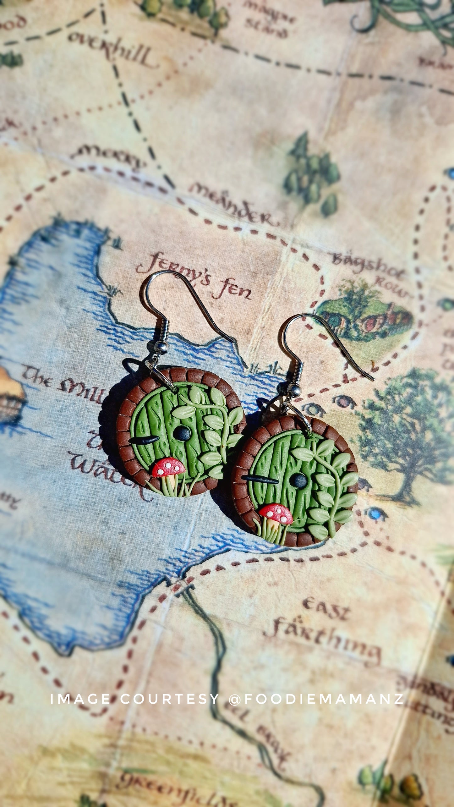 Introducing Hobbit Door Polymer Clay Earrings by silverstar.nz, showcasing a forest scene with trees and mushrooms on a vintage-style map.