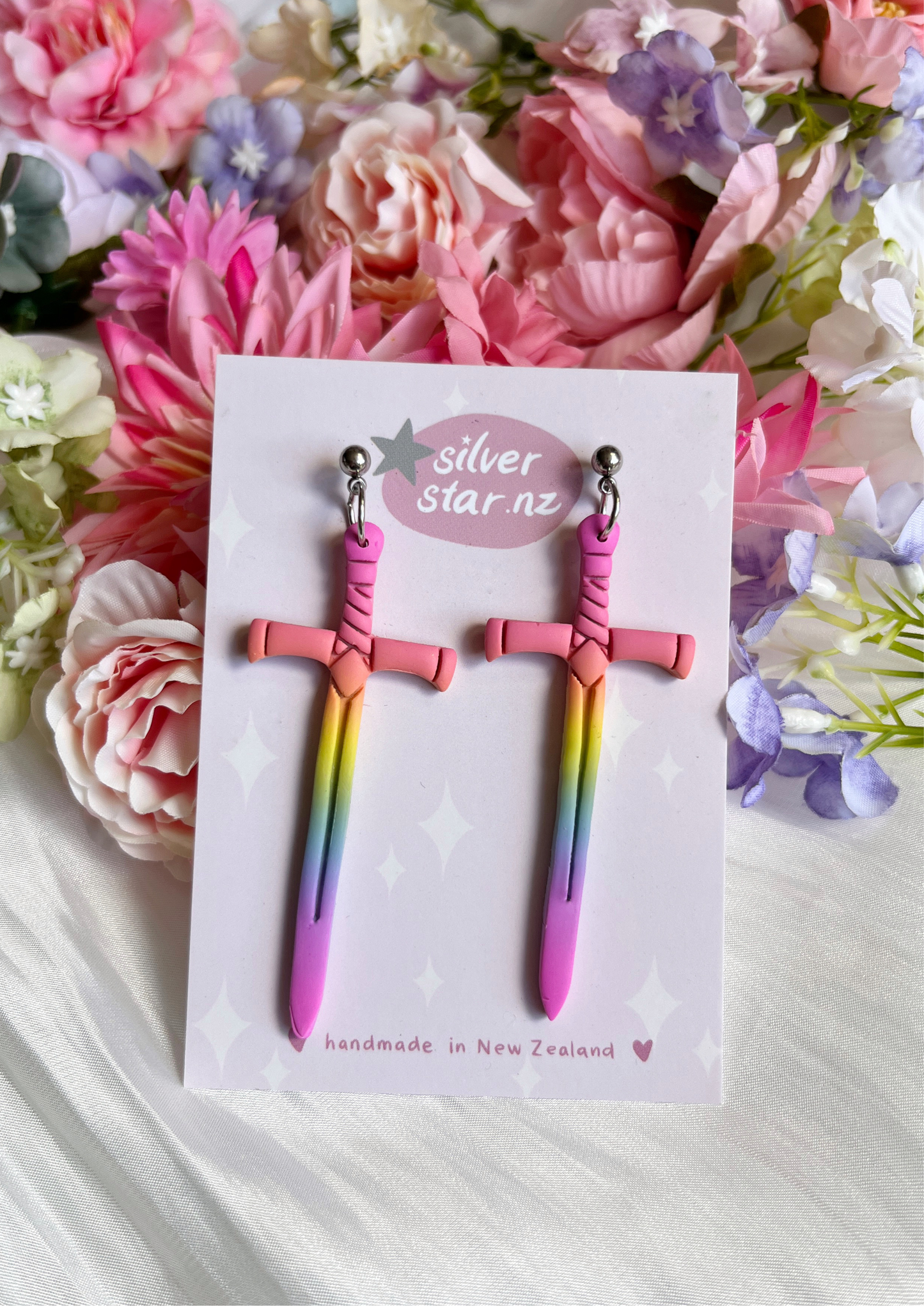 These Sword Polymer Clay Earrings from silverstar.nz feature pastel, sword-shaped handmade designs that fade from pink to blue. They come on a decorative card with stars and flowers, and are fitted with durable stainless steel hooks.